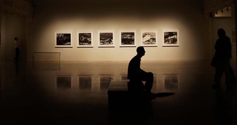 una persona sentada en una sala de exposiciones