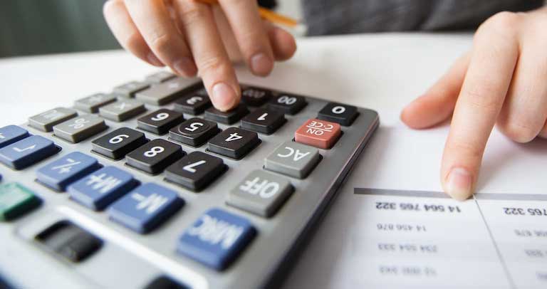 Profesional realizando balance económico en una calculadora