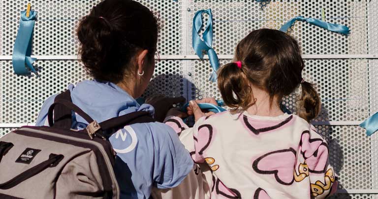 Una familia enlazando el lazo azul