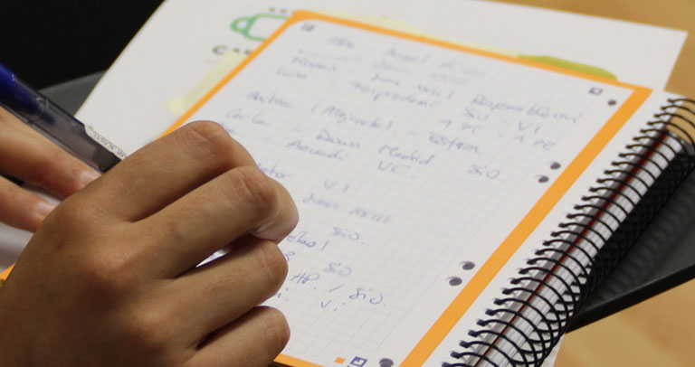 Participante toma notas en la sesión